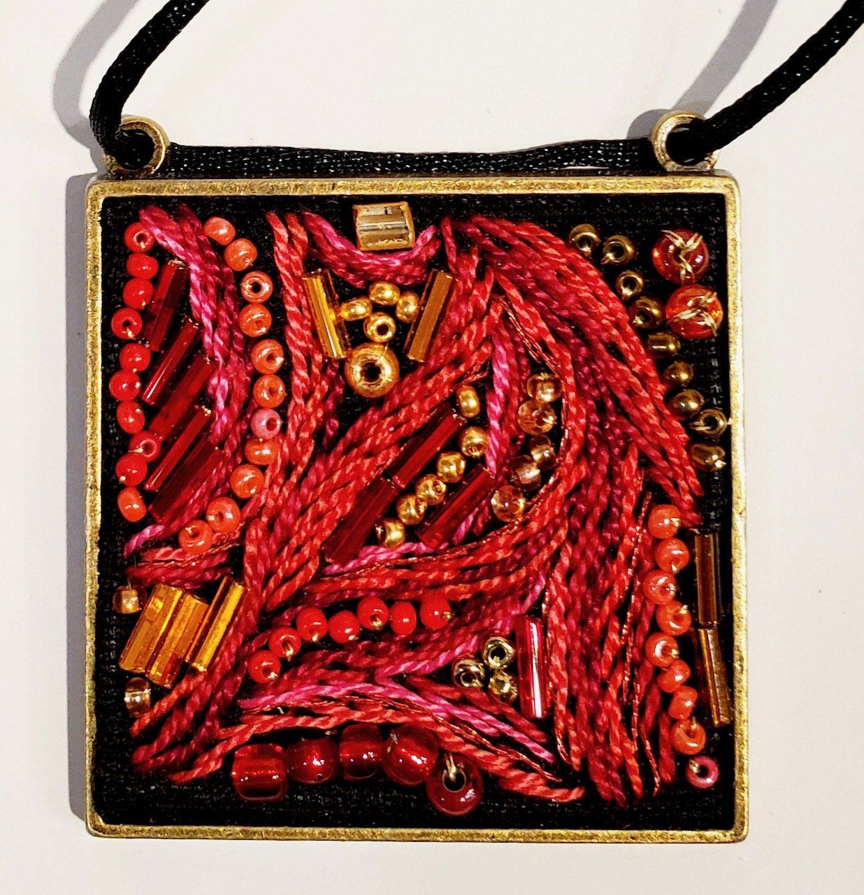 A necklace with red and gold beads on it