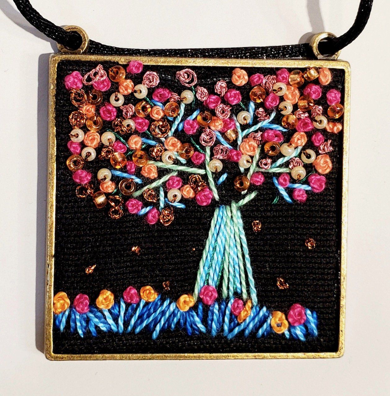 A necklace with a tree embroidered on it