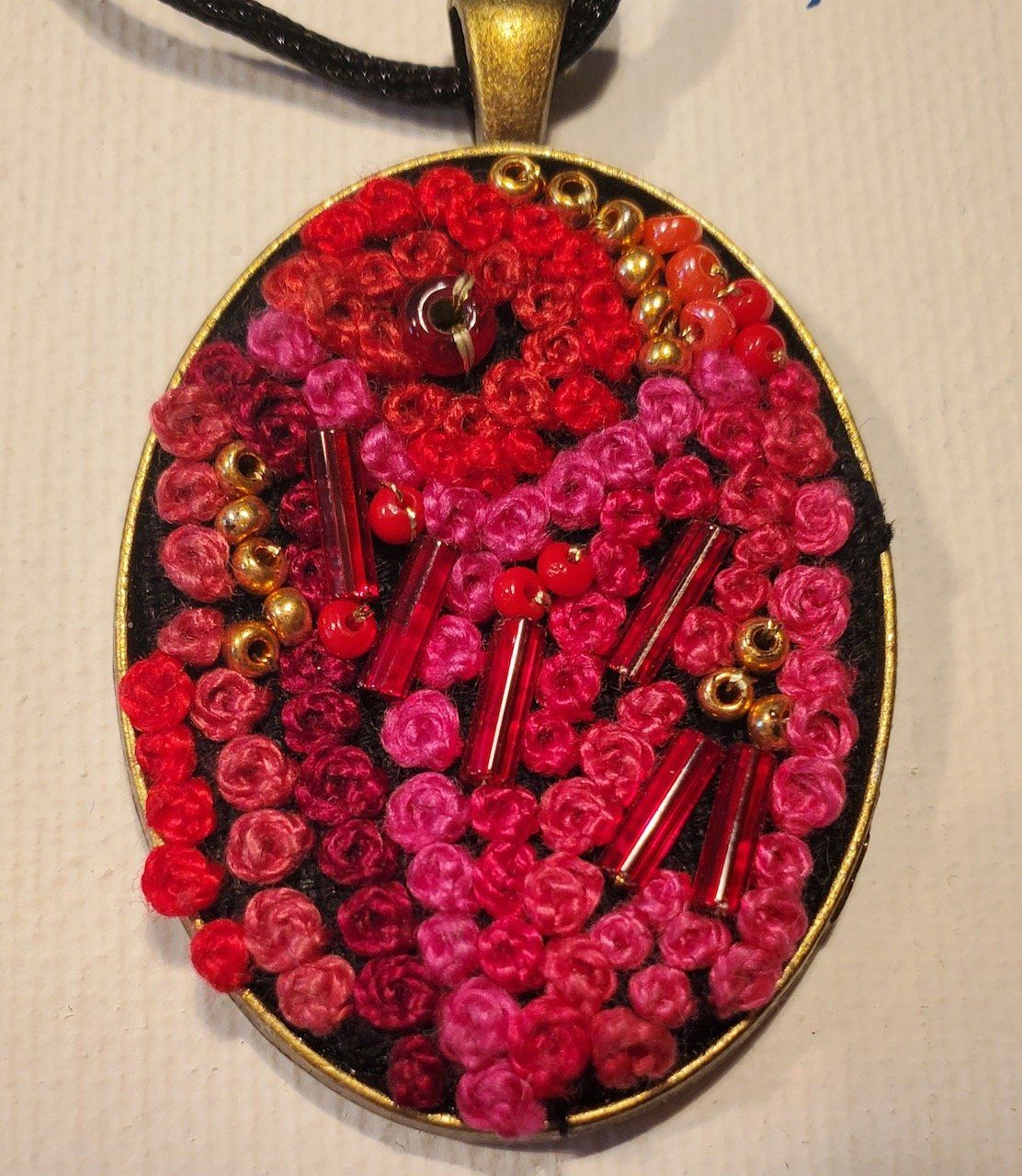 A pendant with red and pink beads on it