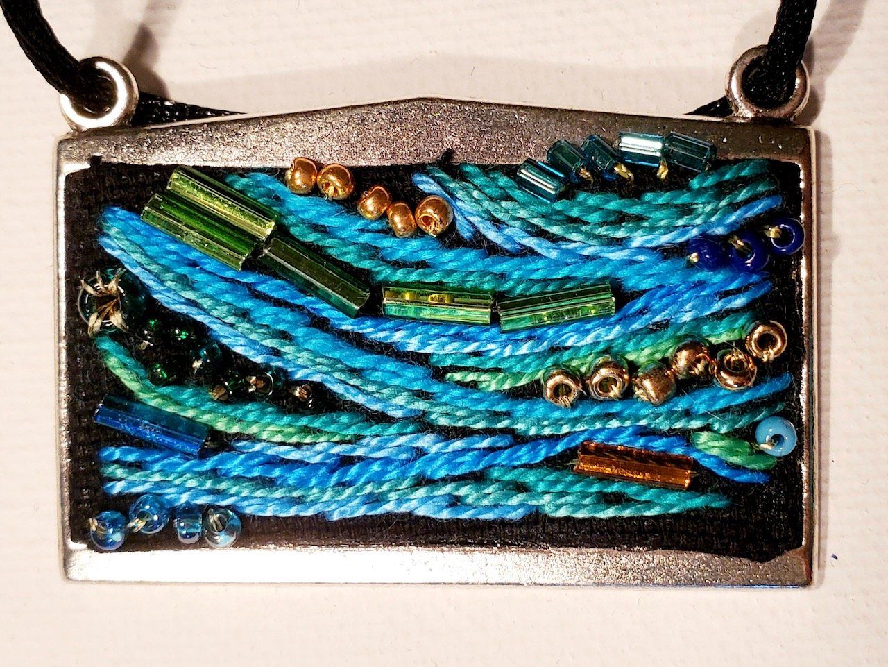 A necklace with blue and green beads on it