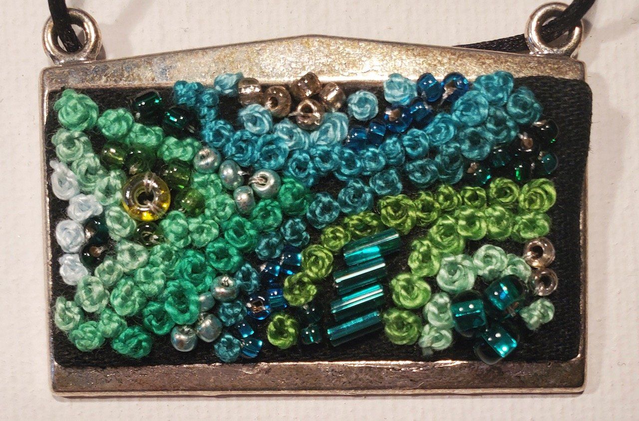 A necklace with blue and green beads on it