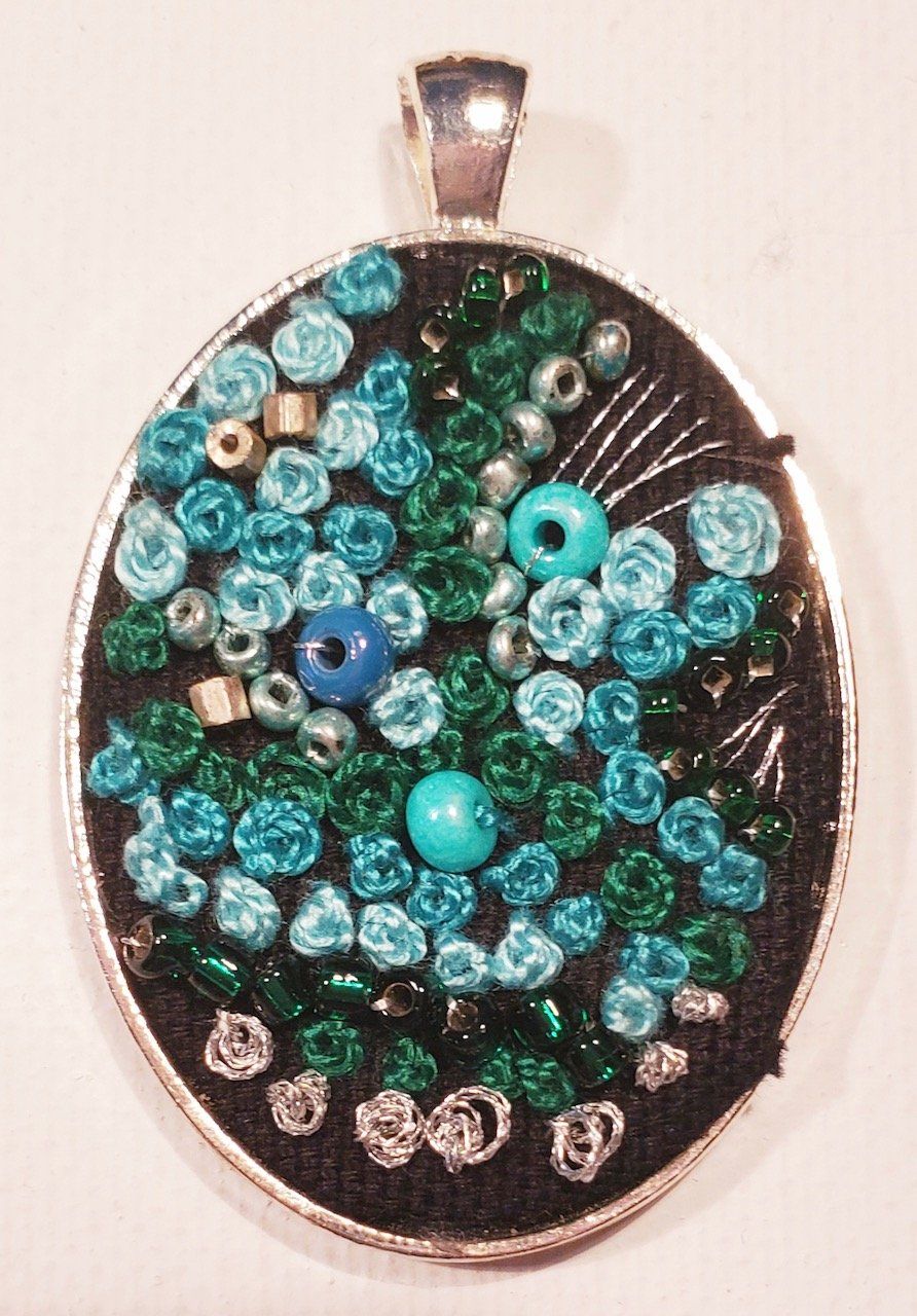 A pendant with blue and green beads on it