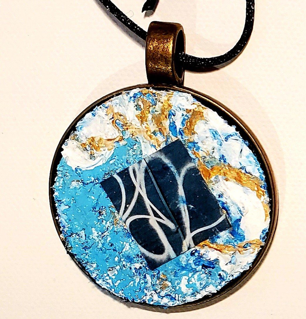 A necklace with a blue and white pendant on a black cord