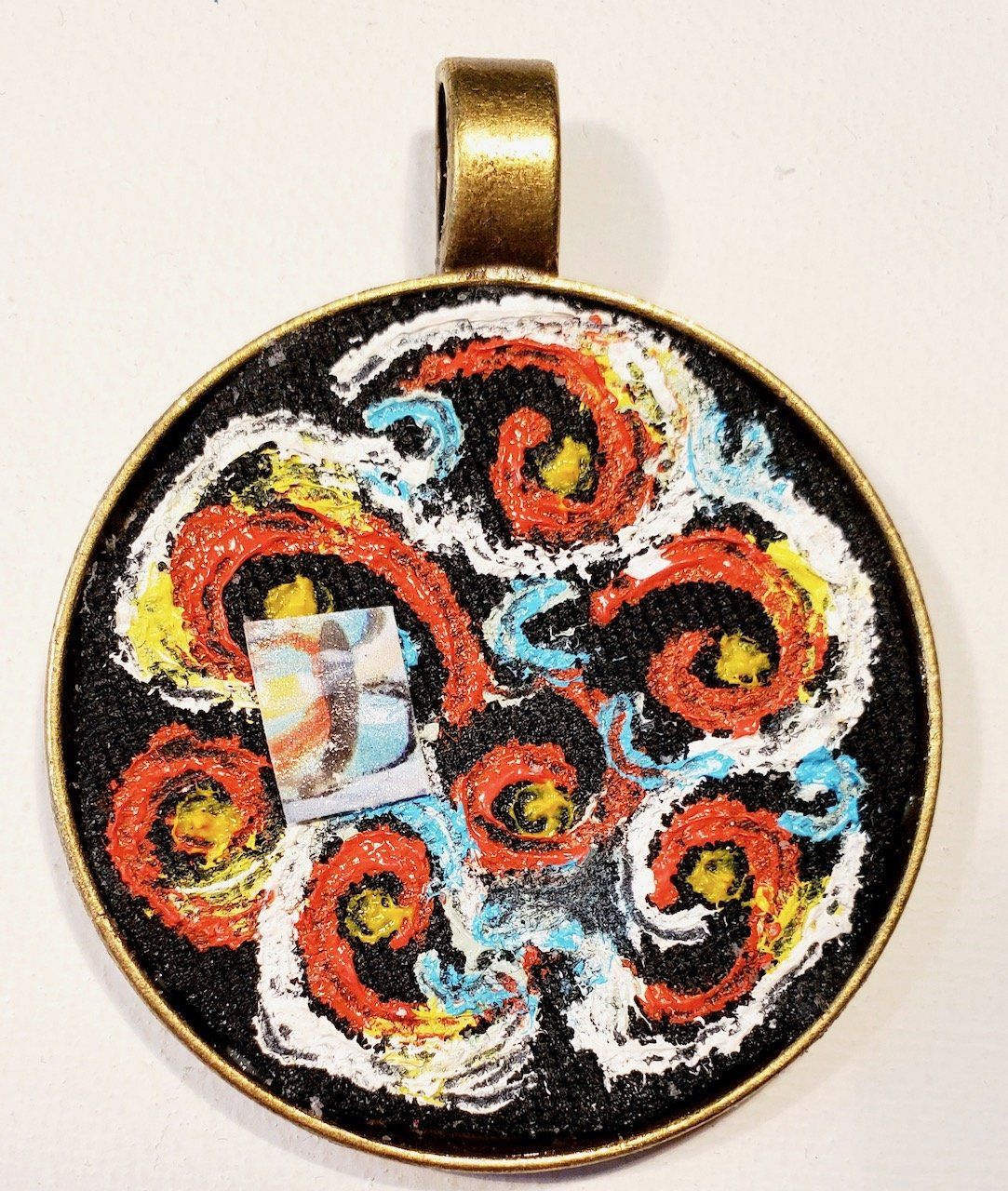 A pendant with a colorful design on it