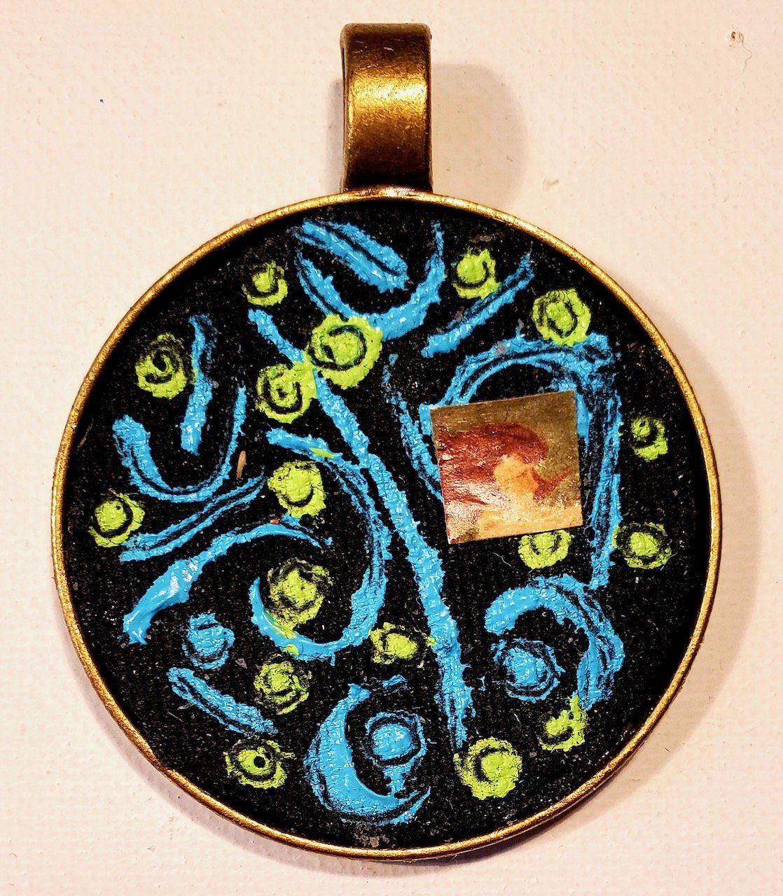 A pendant with a tree of life design on it