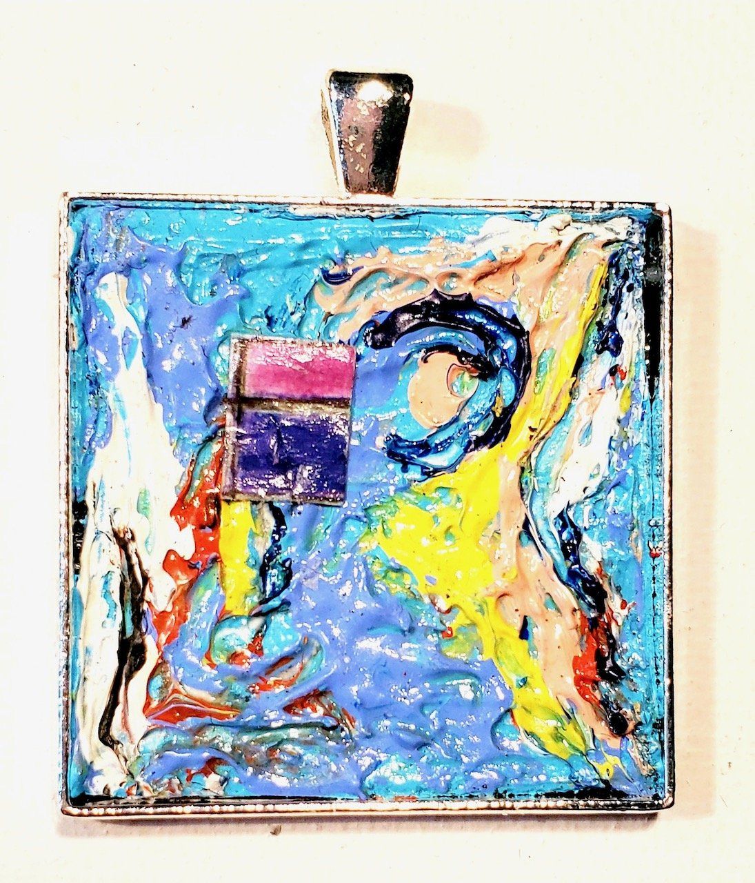 A square pendant with a colorful design on it