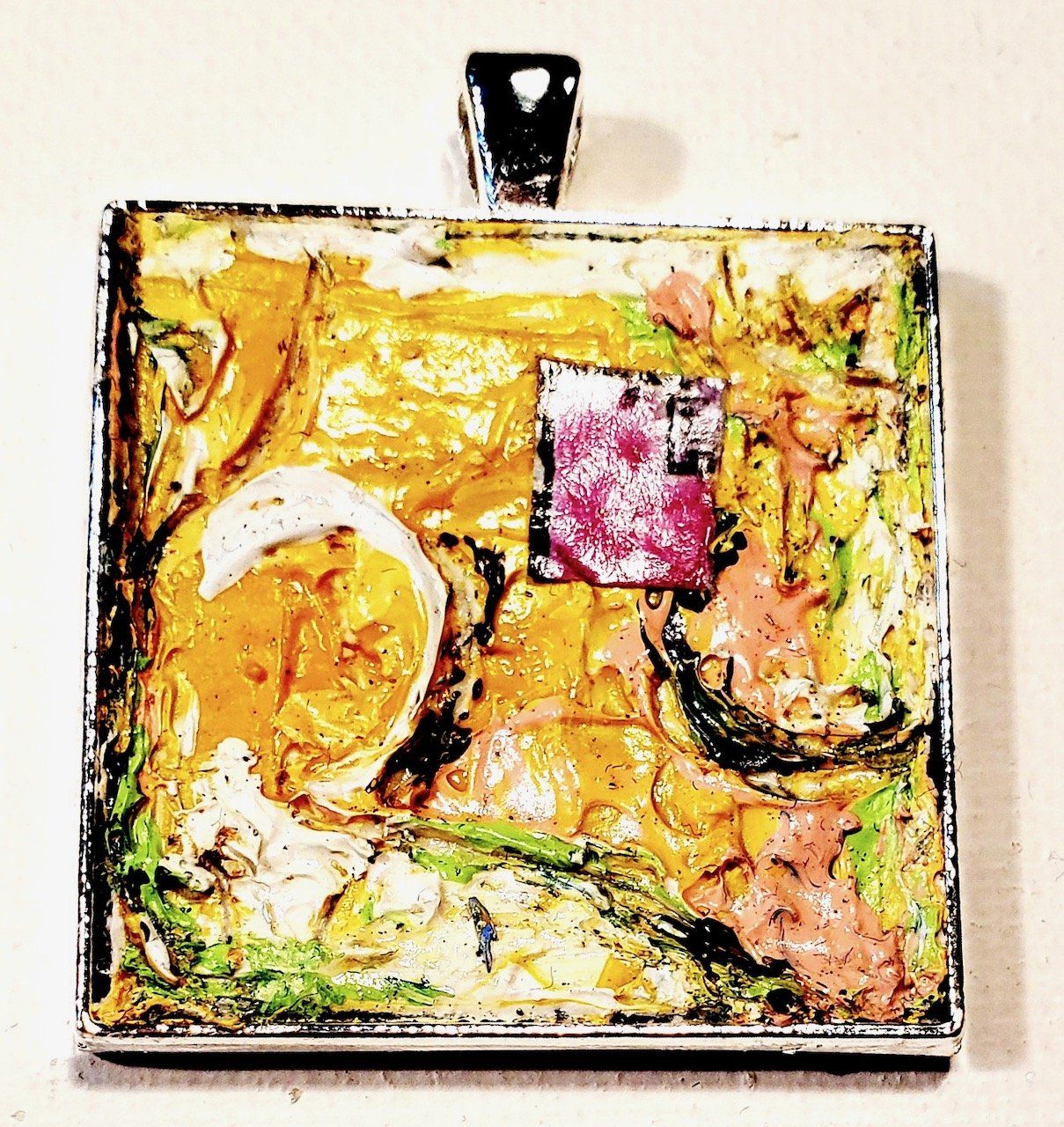 A square pendant with a purple square in the middle