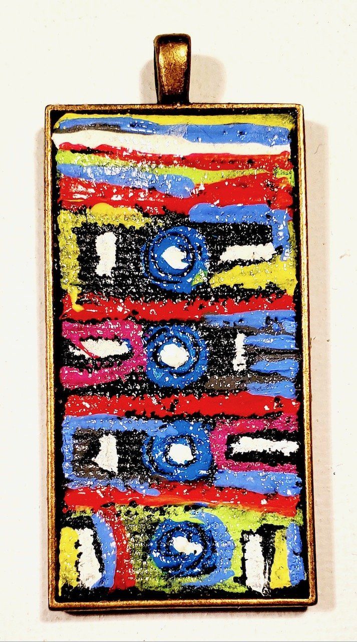 A pendant with a colorful design that says i love you