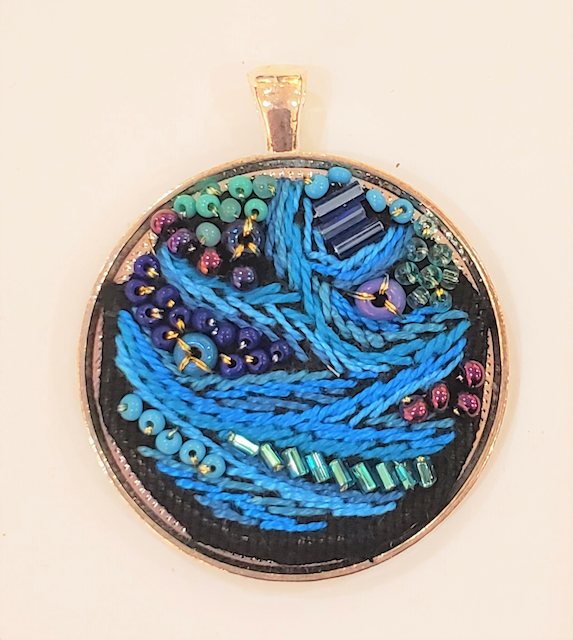 A round pendant with blue beads on it