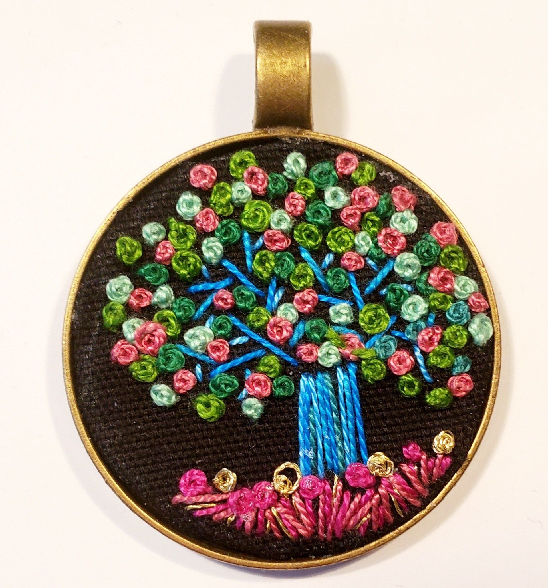 A pendant with a tree embroidered on it