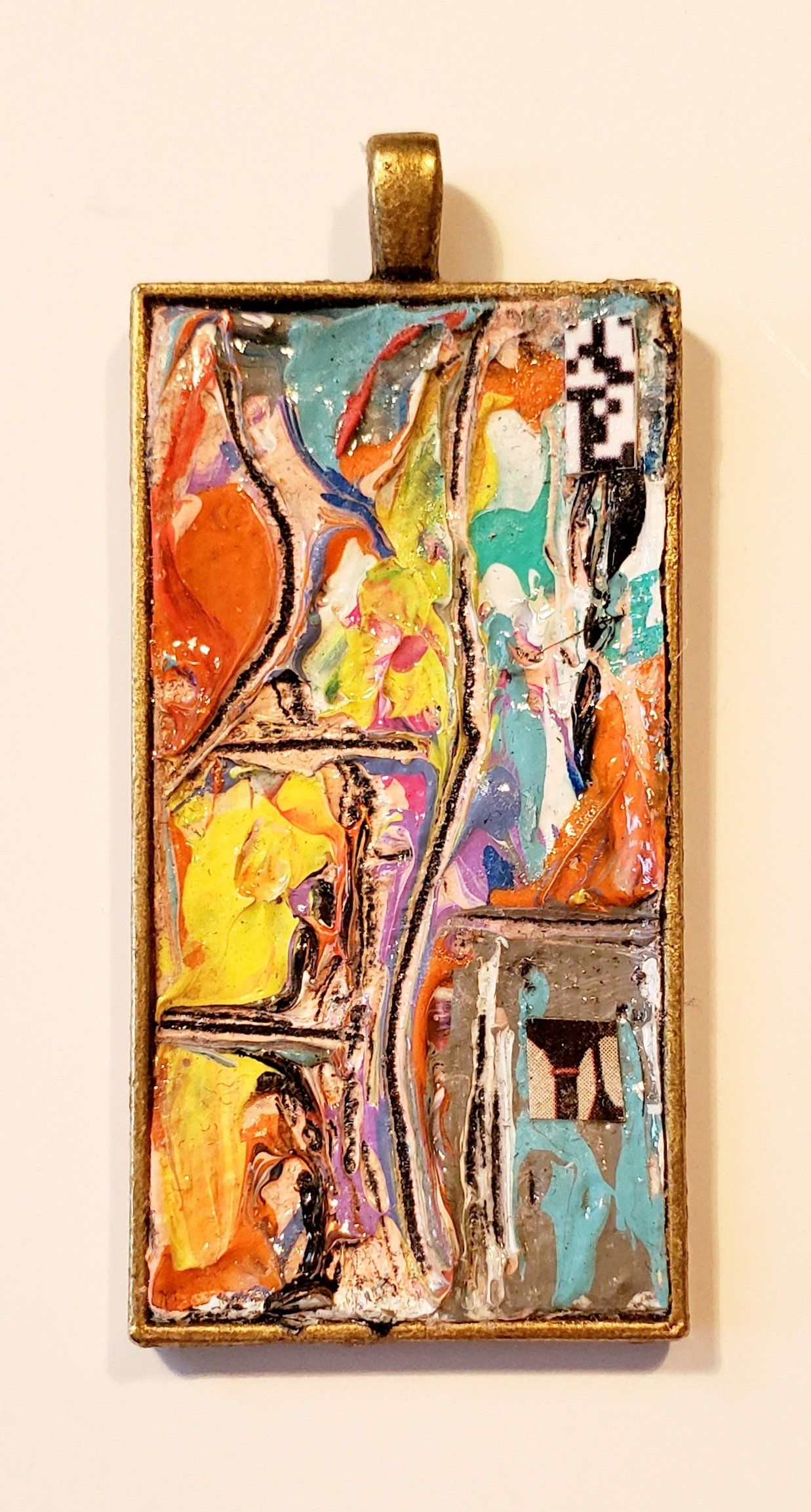 A colorful painting is hanging on a white wall.