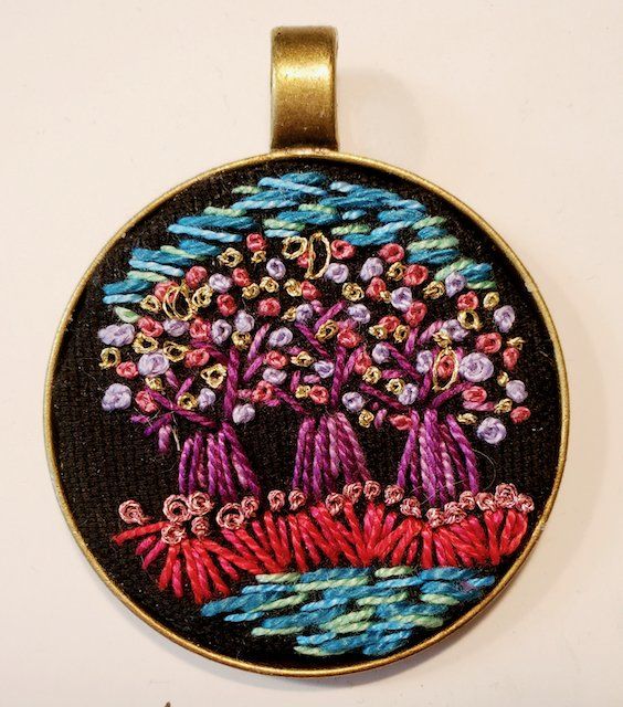 A pendant with a tree embroidered on it