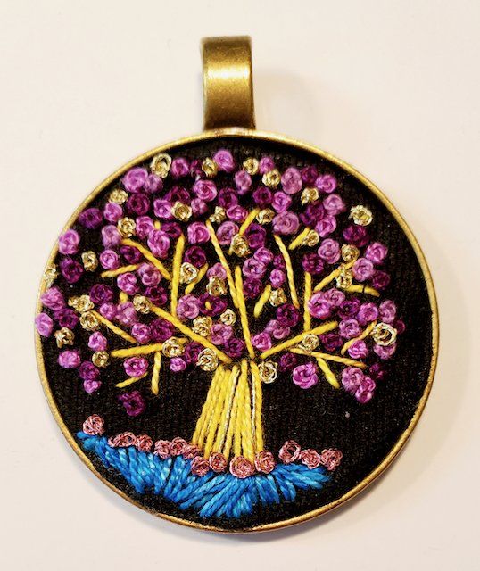 A pendant with a tree embroidered on it