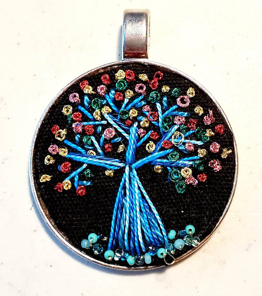 A pendant with a tree embroidered on it