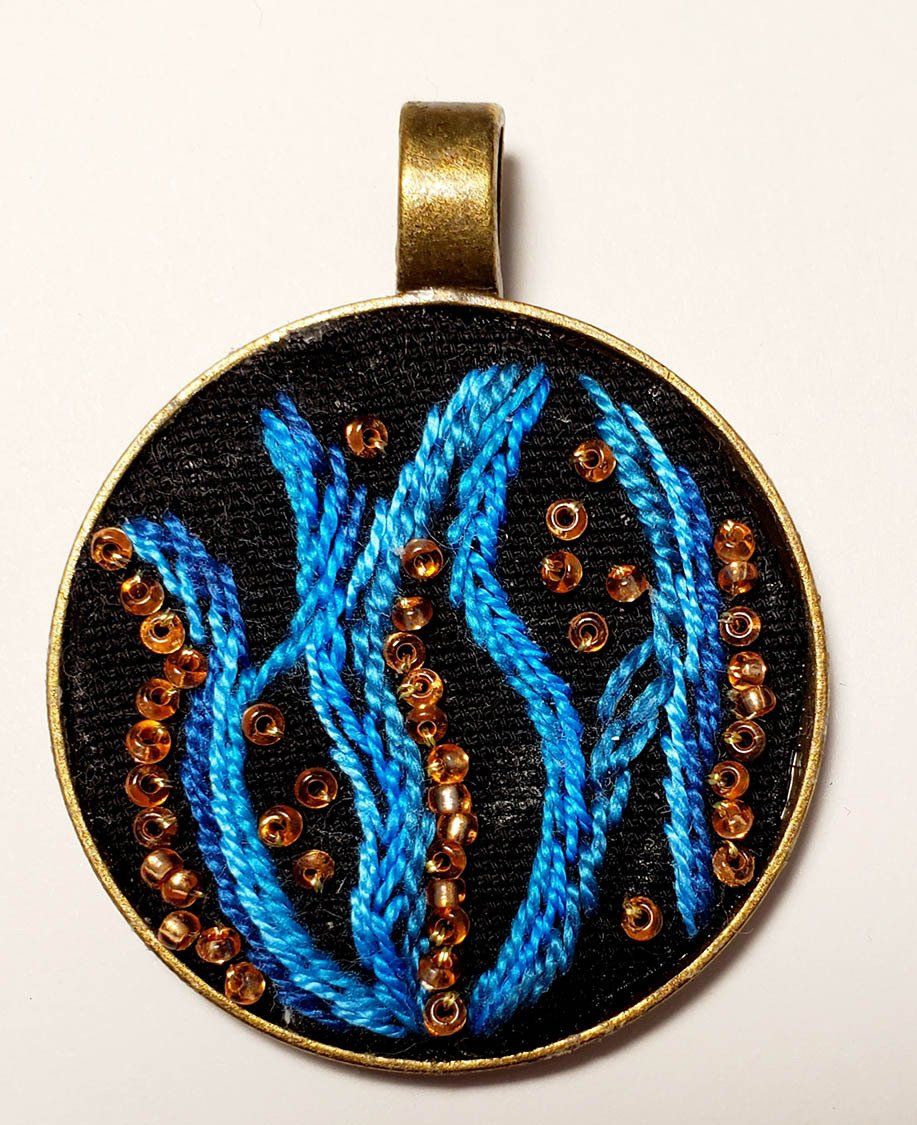 A pendant with a picture of seaweed on it