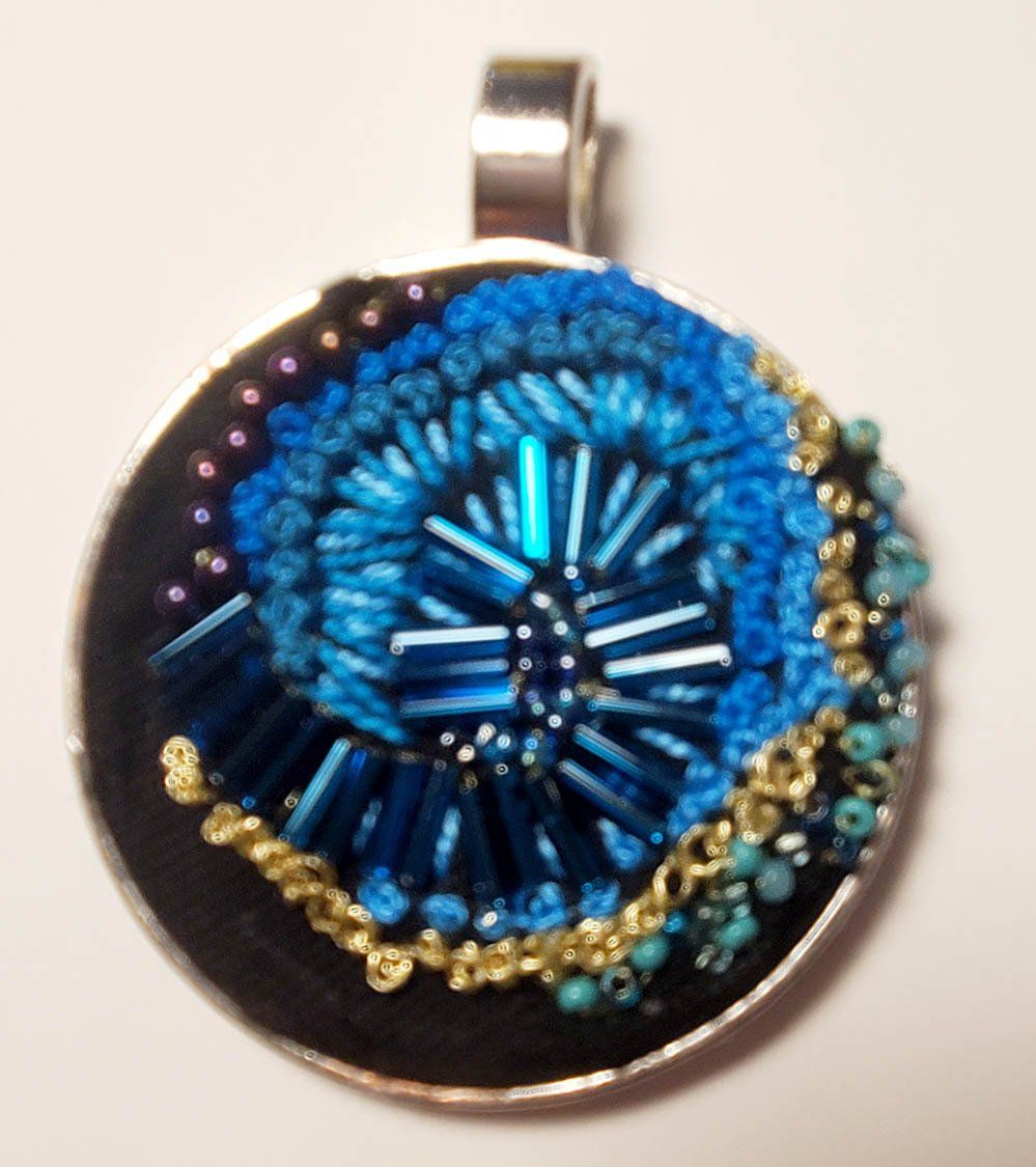 A round pendant with blue beads on it