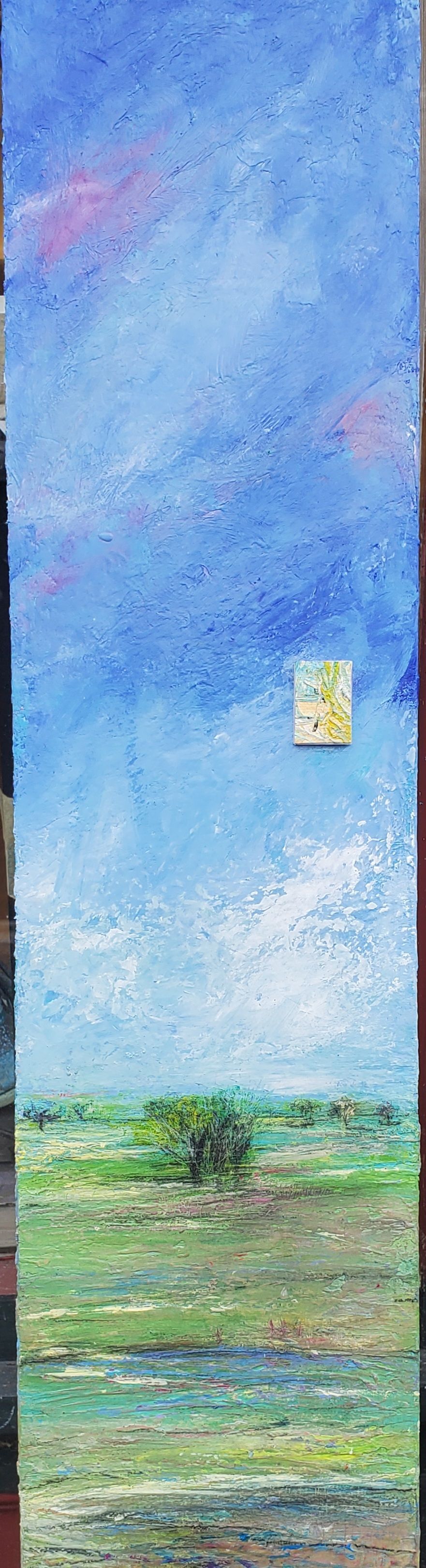 A painting of a field with a house in the distance and a blue sky.