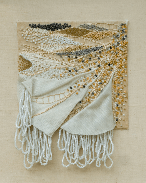 A painting on a wall that looks like a blanket with fringe