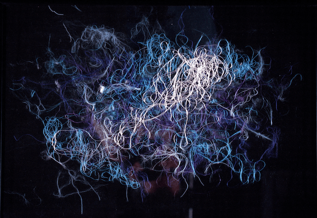 A bunch of swirls are floating in the air on a black background.