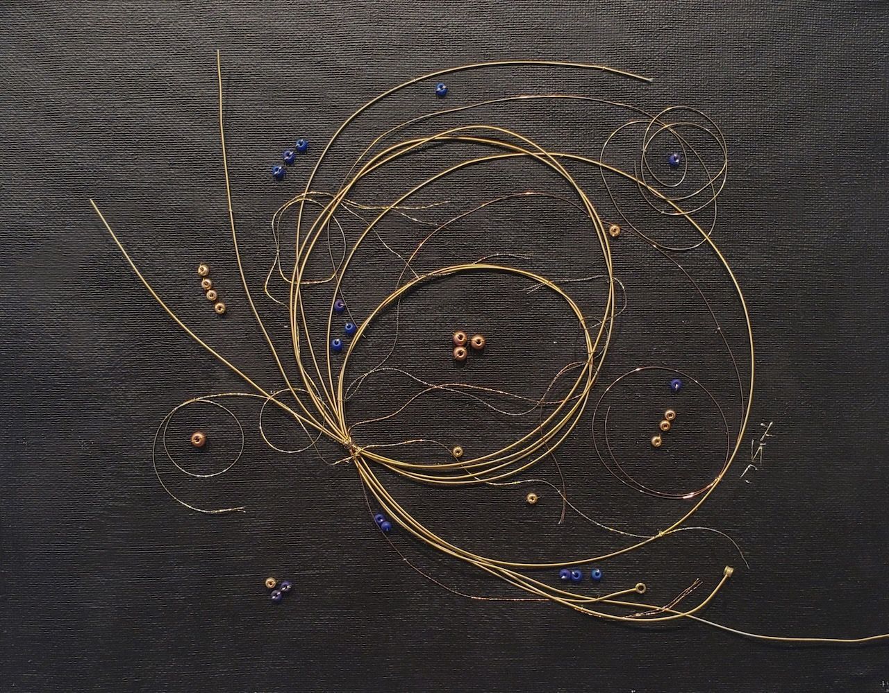 A swirl of wire and beads on a black cloth
