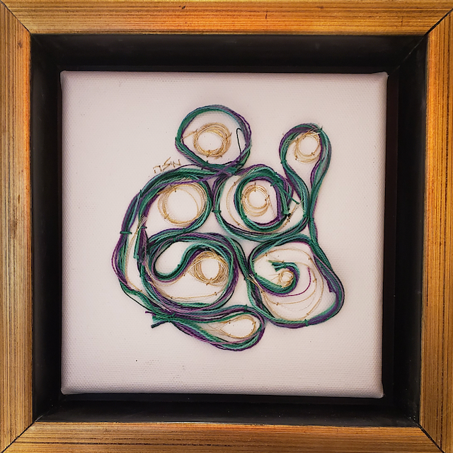 A framed picture of a green and purple swirl