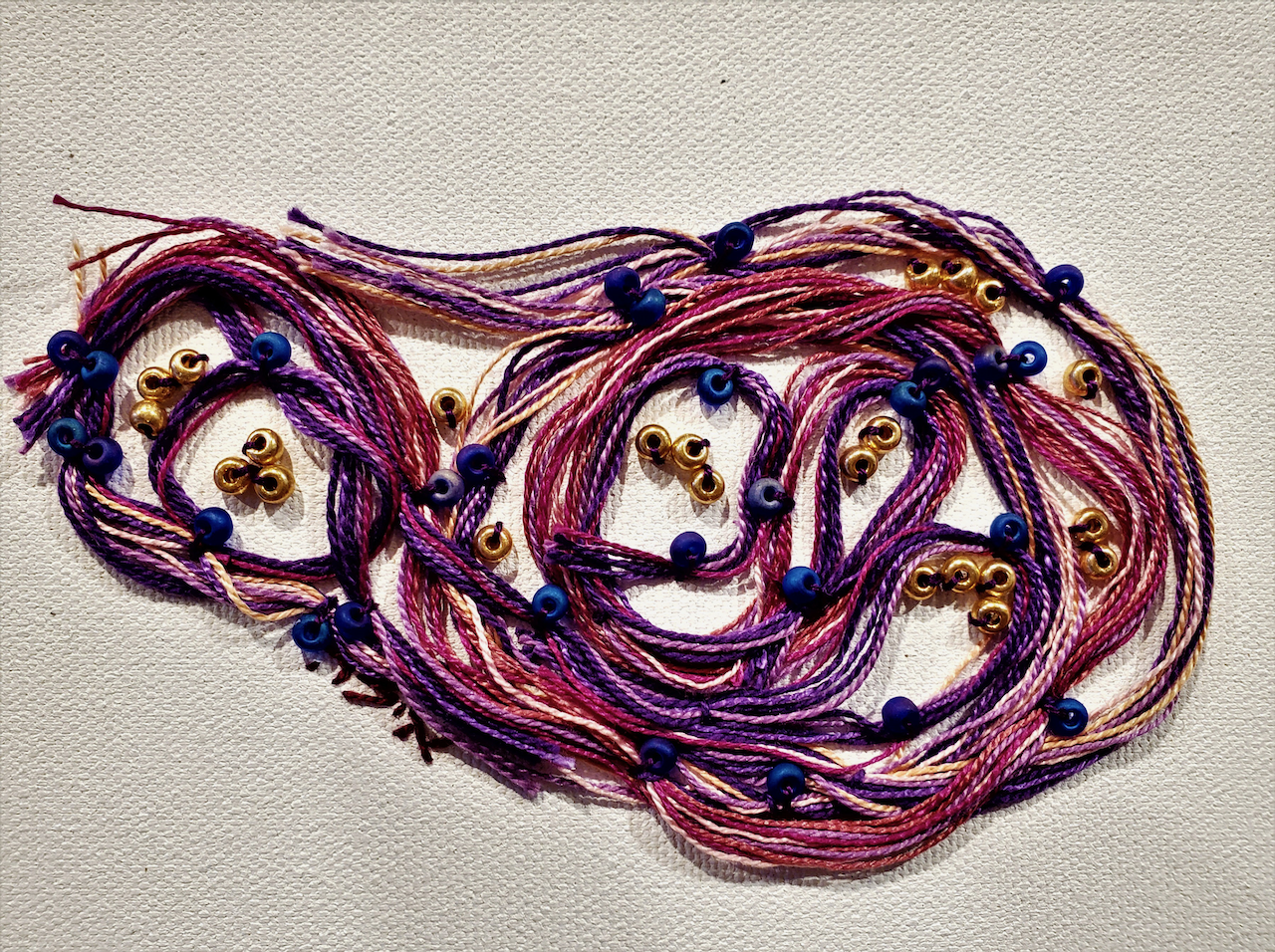 A close up of a piece of yarn and beads on a table.