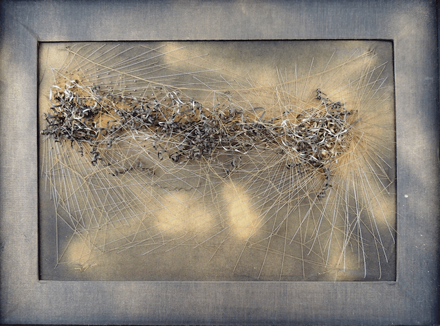 A close up of a painting of a caterpillar in a frame.