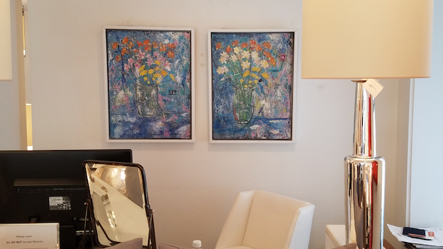 A living room with two paintings on the wall and a lamp