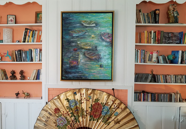 A living room with a fan and a painting on the wall