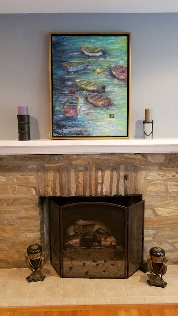 A fireplace with a painting on the mantle above it.