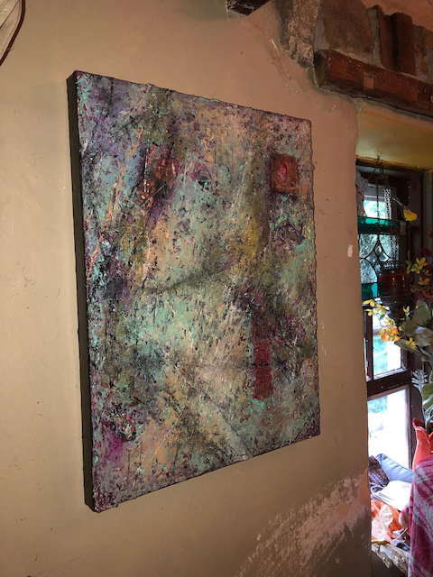 A large painting is hanging on a wall in a room.