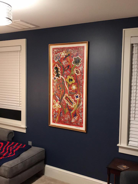 A room with blue walls and a painting on the wall