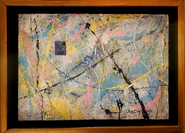 A colorful painting is in a wooden frame.