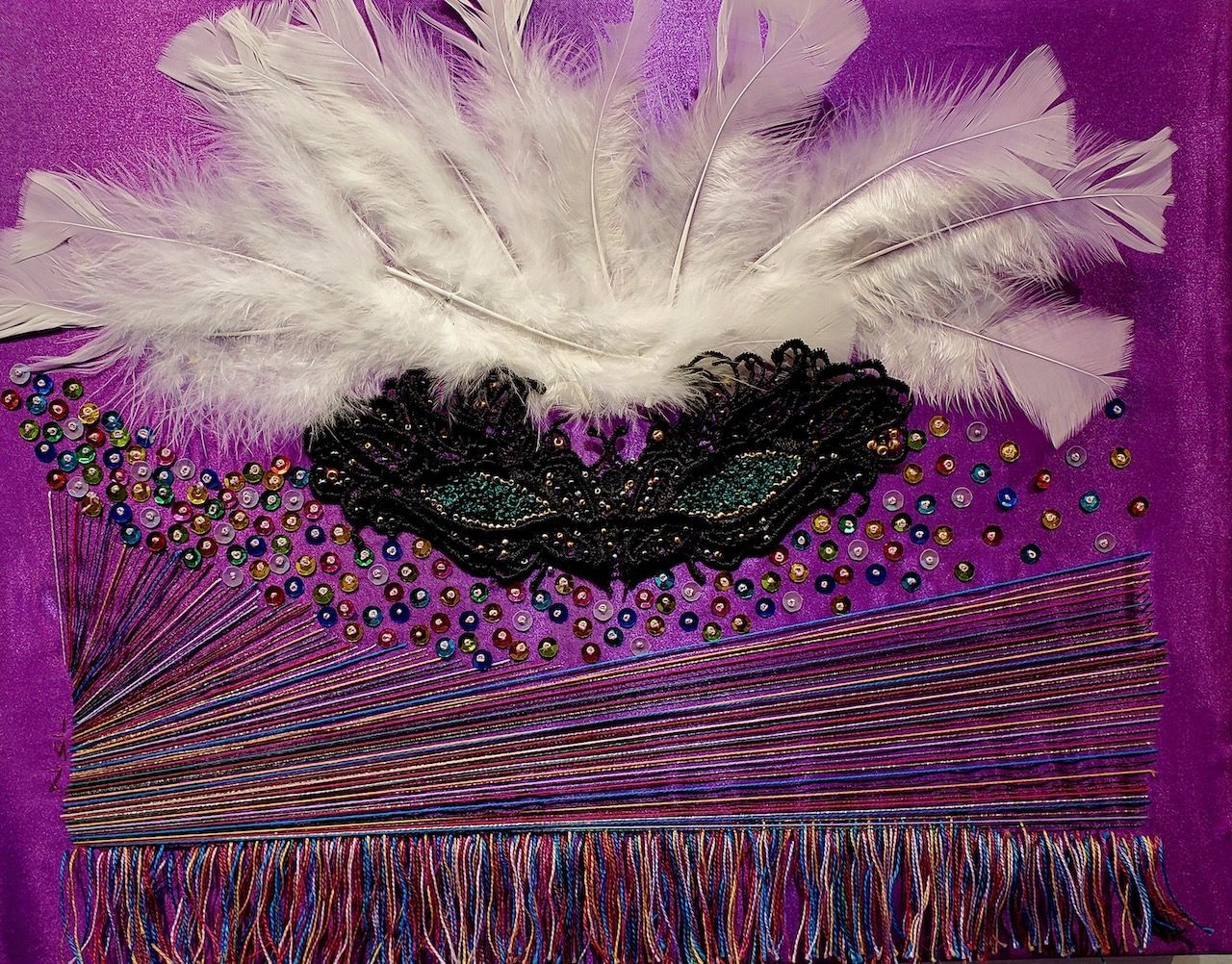 A purple background with feathers and beads on it