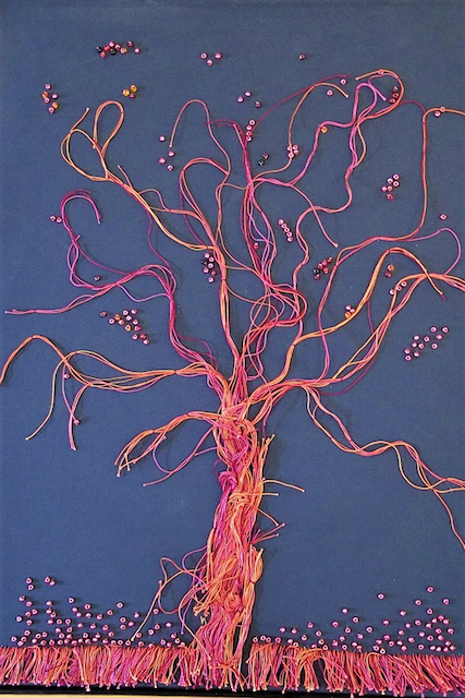 A painting of a tree made of yarn and beads