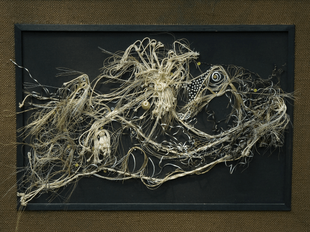 A painting of a frog is hanging on a wall in a black frame.