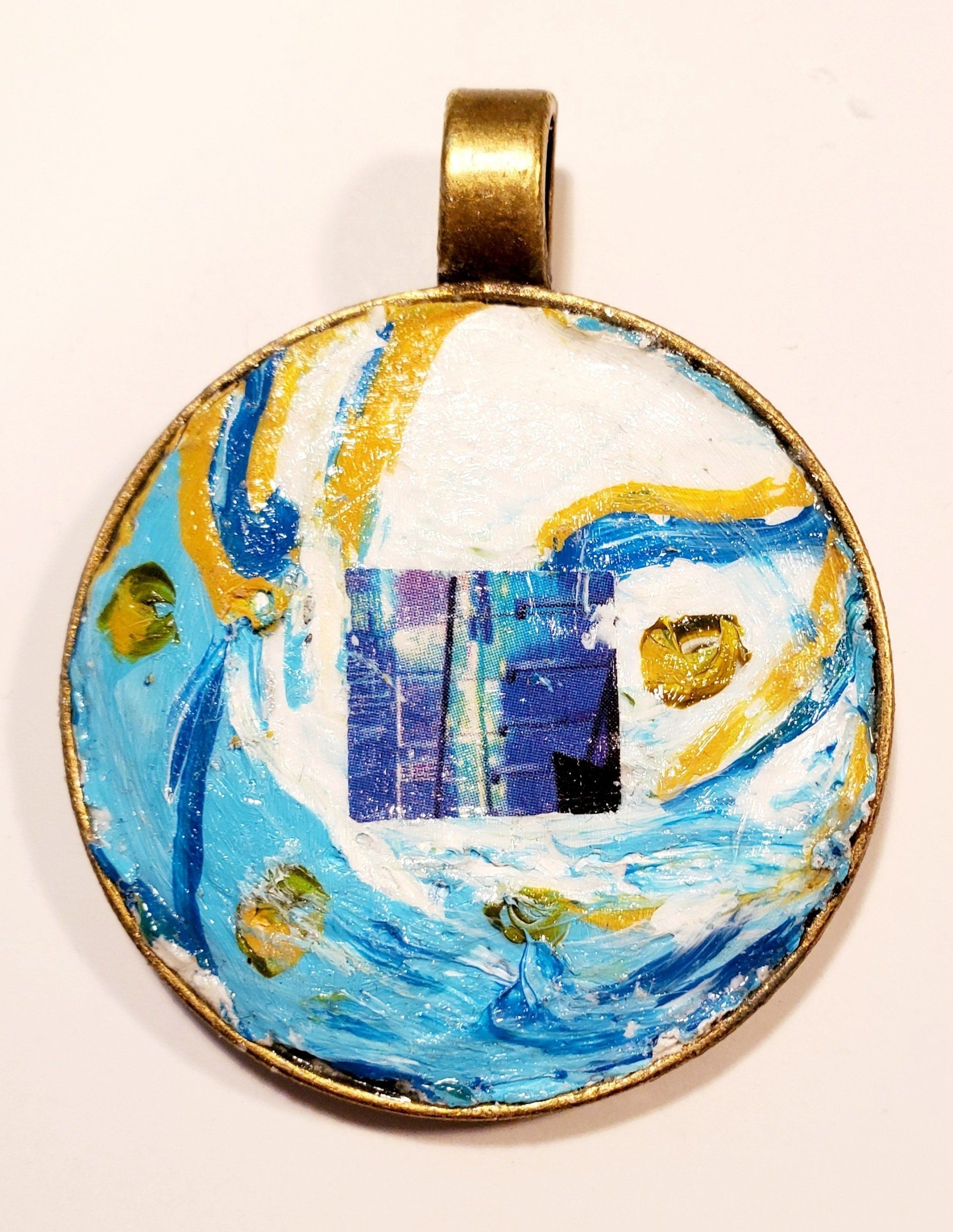 A pendant with a blue and gold design on it