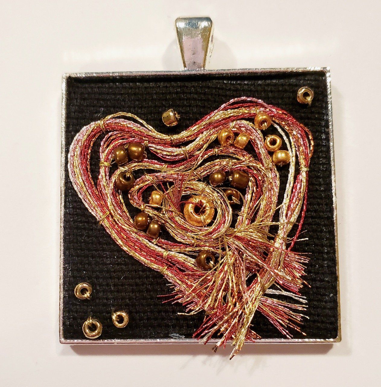 A pendant with a heart shaped design on it