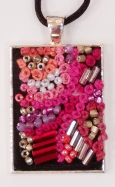 A pendant with pink and purple beads on it