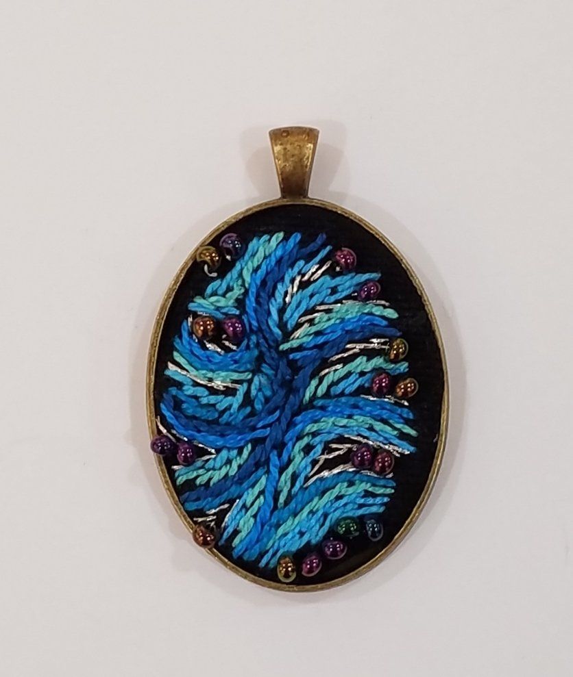 A pendant with a blue and purple design on it