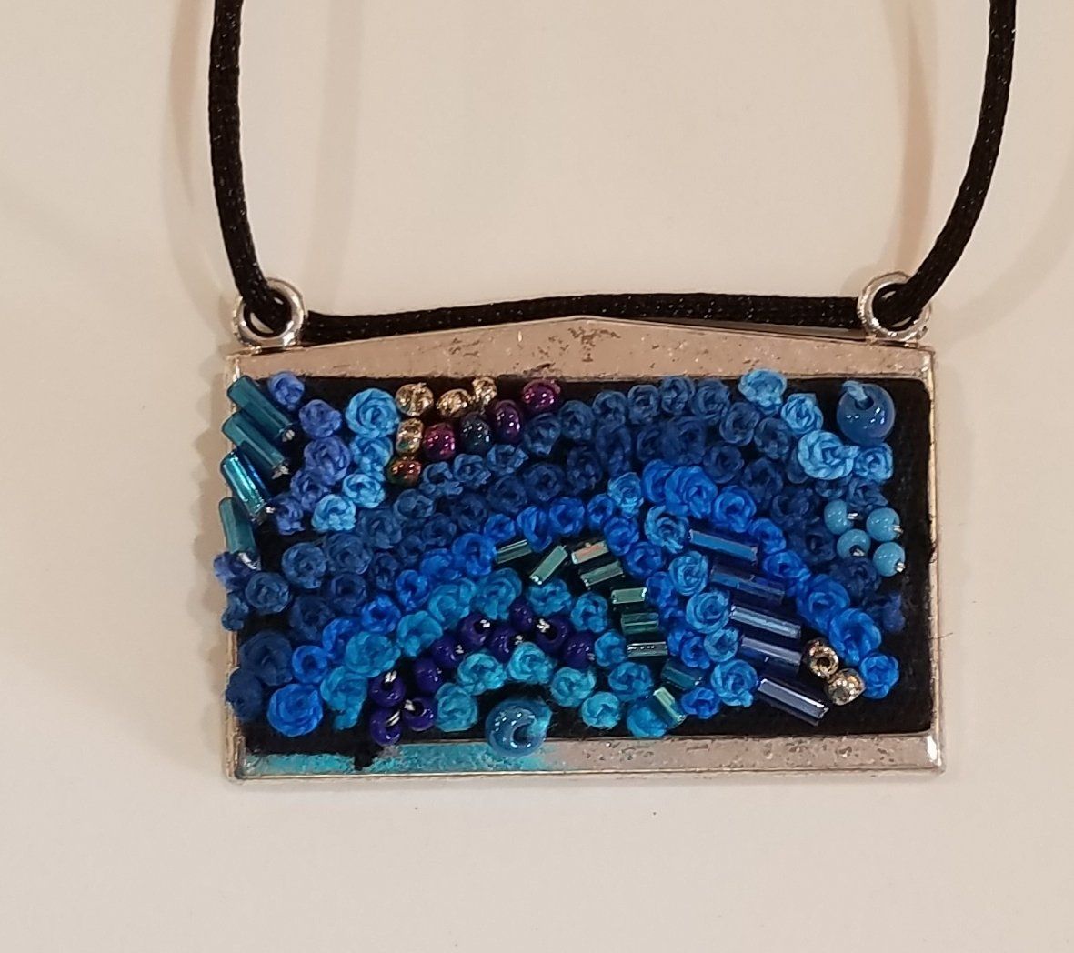 A necklace with blue beads on a black cord