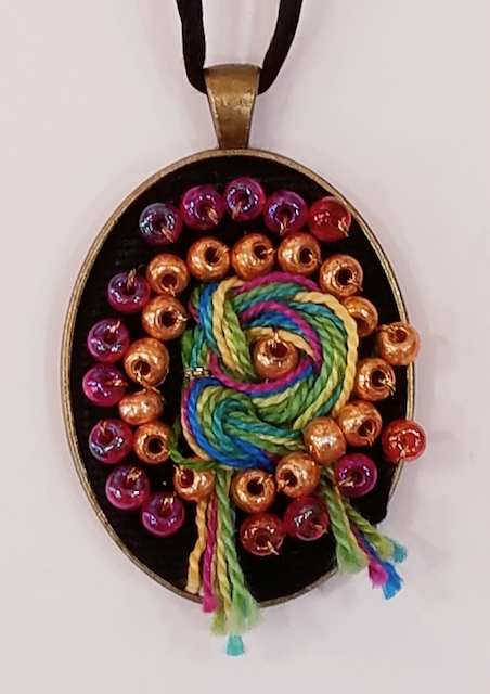 A necklace with beads and yarn on it