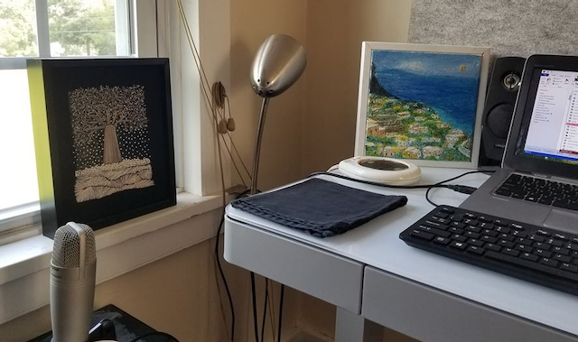 A desk with a laptop and a picture on it