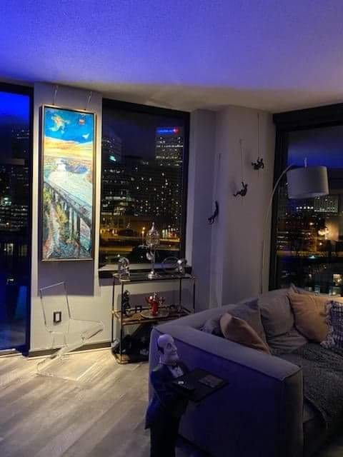 A living room with a couch and a painting on the wall