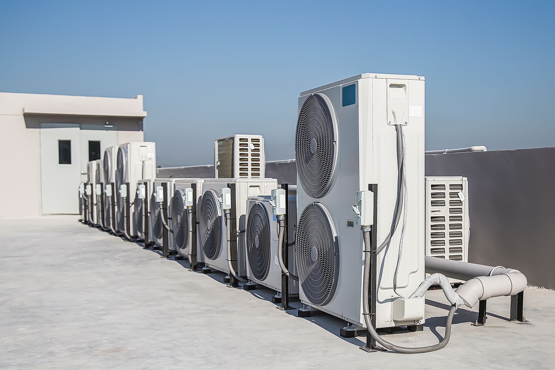 A Row of Air Conditioners Are Lined up on the Roof of a Building — Independence, MO — McIntosh Heating & Cooling