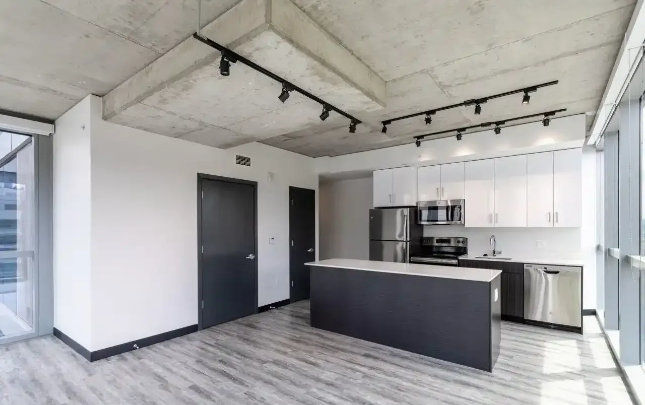 Open-concept kitchen with island, white cabinets, and stainless-steel appliances.