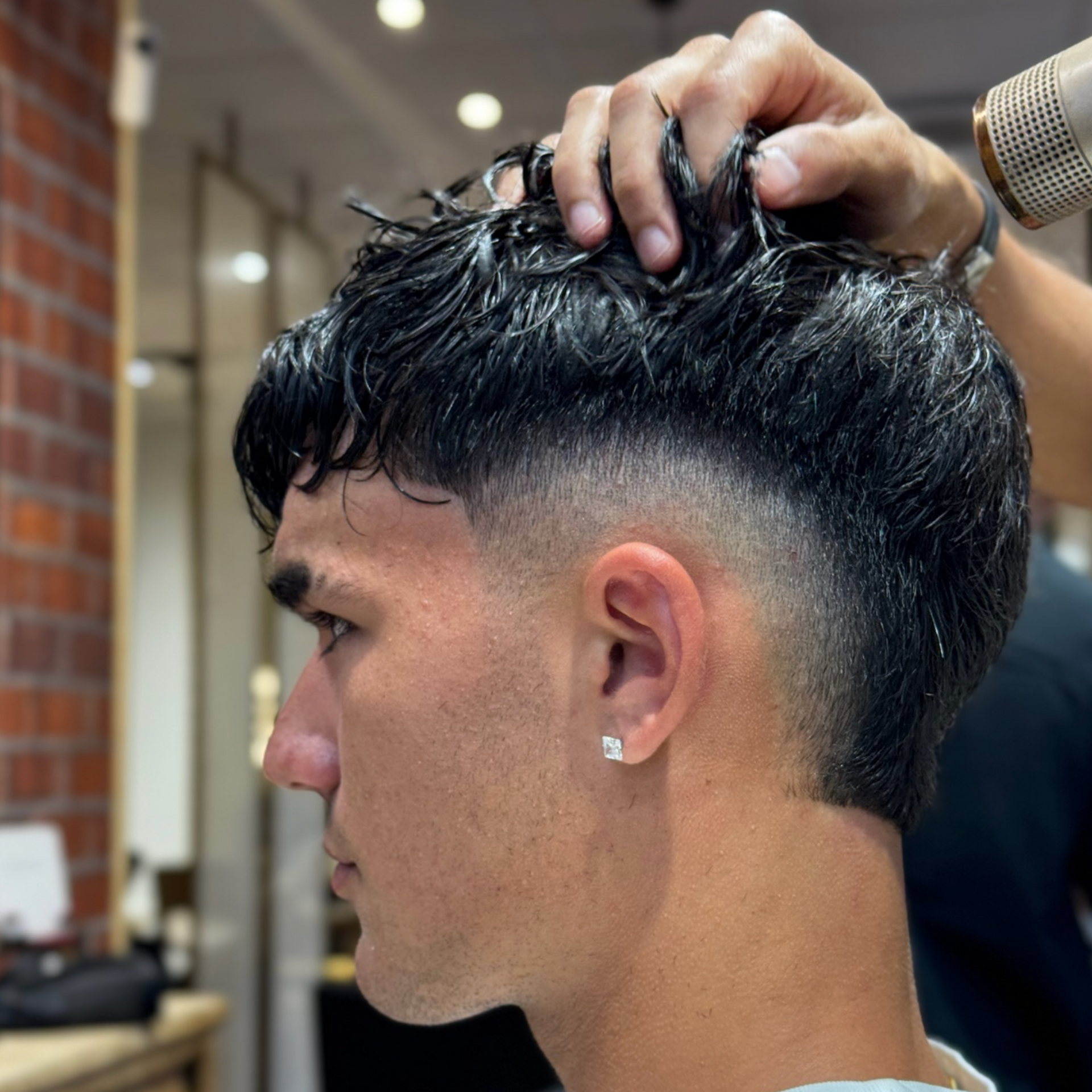 Un barbero le está cortando el pelo a un hombre con una maquinilla.