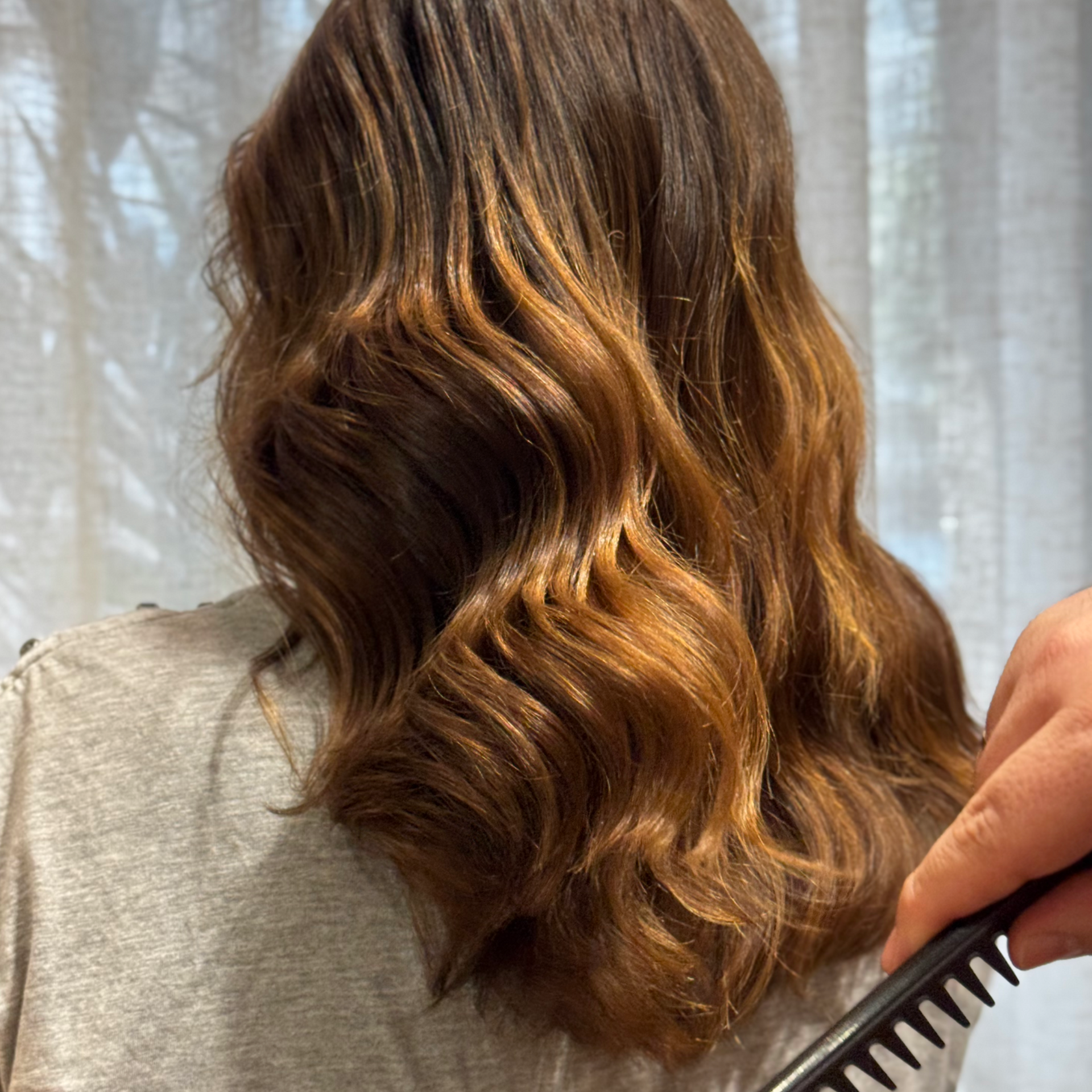 Una mujer con cabello largo y castaño lleva un vestido negro.