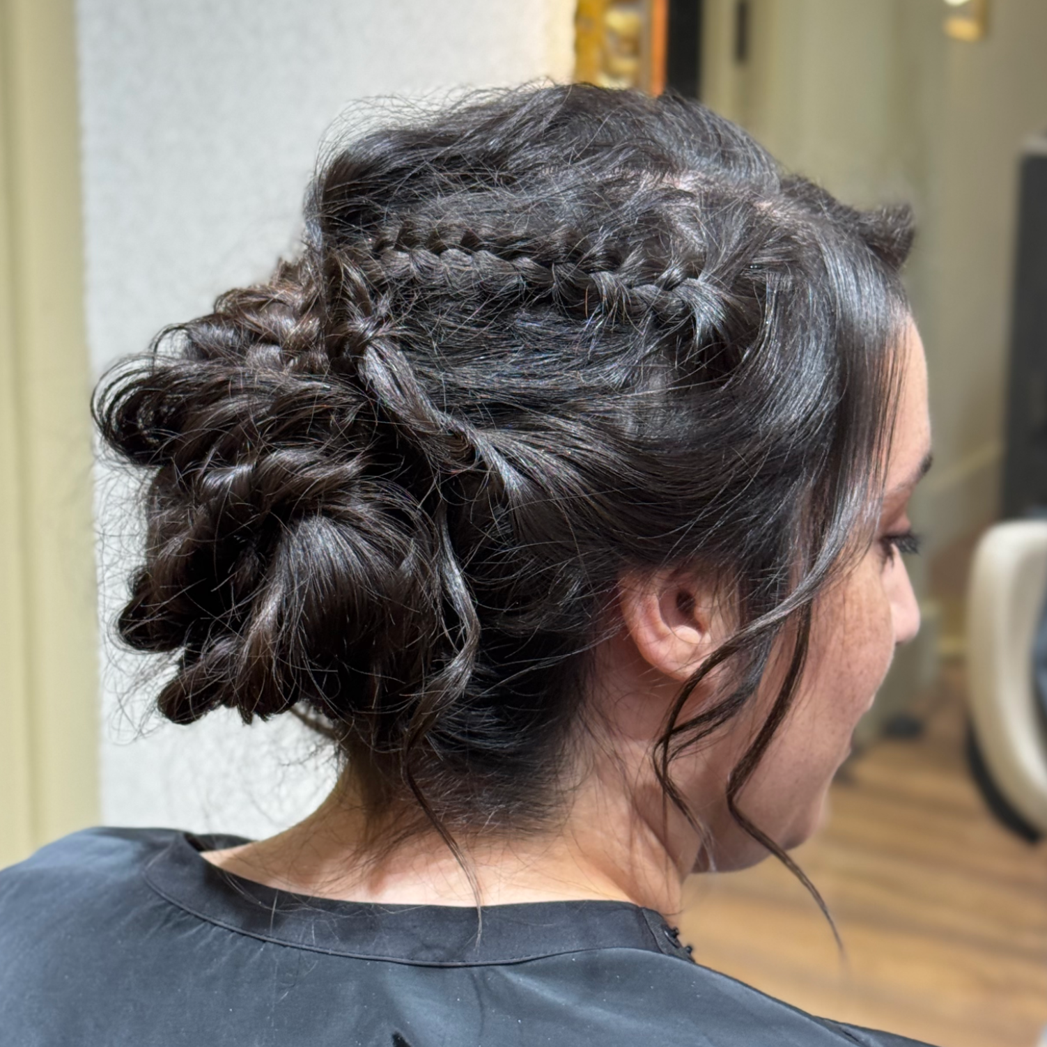 A una mujer con un vestido verde le están rociando el pelo