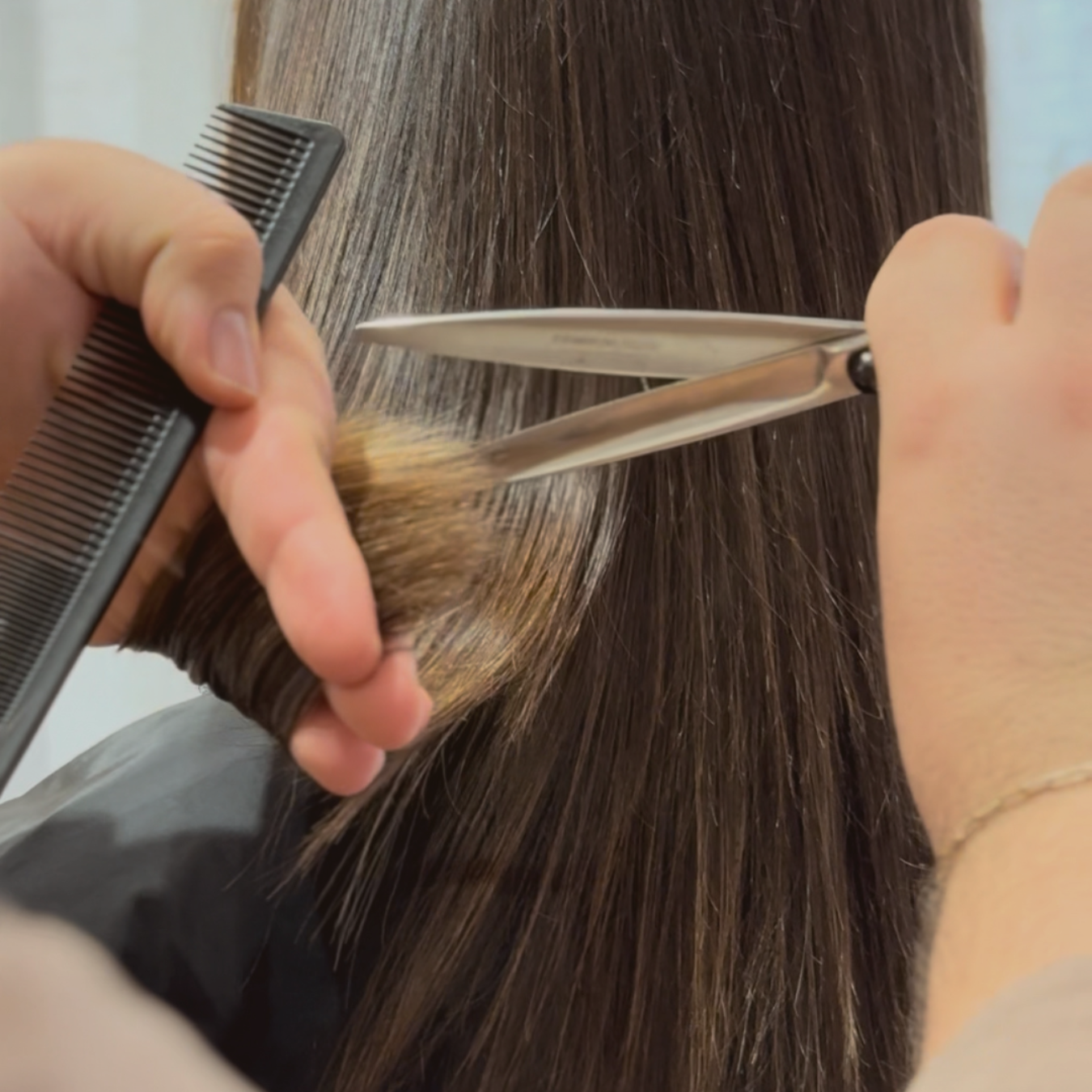 Una persona está siendo cortada por un peluquero